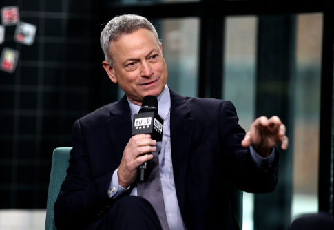 A man in a suit speaking into a microphone during an interview