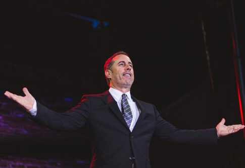 Jerry Seinfeld performing stand-up comedy on stage